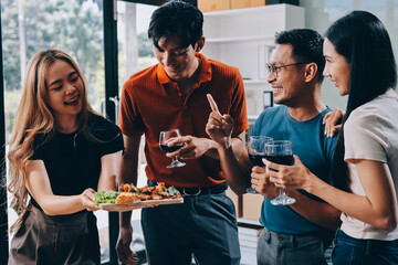 Asian office colleagues and friends enjoy a daytime BBQ with pizza and beer, celebrating Halloween and cheering for their favorite soccer team, creating a lively atmosphere filled with joy.
