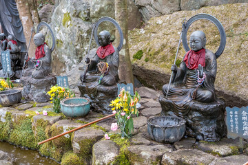 Jizo Statuen mit Gebetsketten und roten Schals in Japan