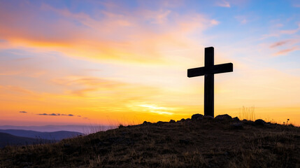 A weathered wooden cross against a colorful sunset sky
