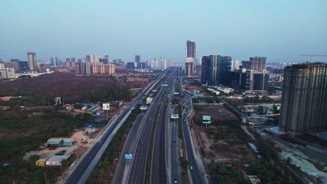 nehru outer ring road with under construction building and trees at financial district, nanakramguda, hyderabad, telangana, india. day time, push in, drone shot, 4k.