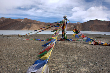 Prayer flag for blessing at viewpoint with Himalayas mountains and Pangong Tso high grassland lake...