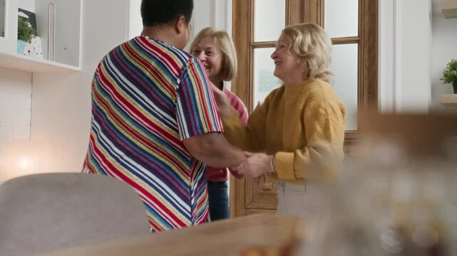 Senior Women Friends Gathering at Home - Mature Ladies Socializing Indoors talking. Three cheerful 60 year old women enjoying friendly get together in living room and chatting. Leisure time