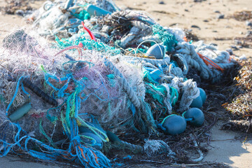 Fishing nets washed up by a storm lie on the ocean shore