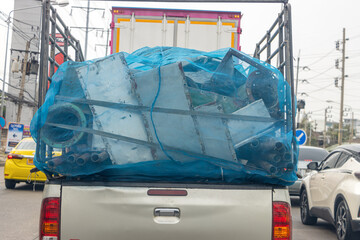 The pick-up car full loaded of an old used construction material ride on the motorway, Thailand