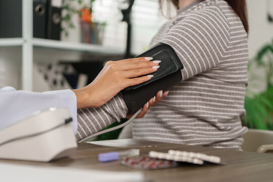 Health Monitoring and Care. A healthcare professional measures a patient's blood pressure, ensuring thoroughness in patient care.