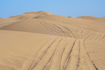 Sand dunes covered with car tracks after a safari. Shot in the desert near the city of Yazd, Iran