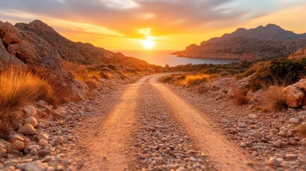 A beautiful rocky road nestled between cliffs and the ocean glows under the warm sunset, inviting contemplation and adventure in nature's embrace.
