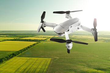 Drone with camera flying over fields. Unmanned aerial vehicle for surveillance