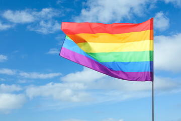 LGBT flag fluttering against beautiful blue sky