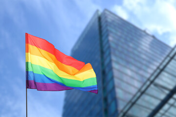 LGBT flag fluttering against building outdoors, low angle view