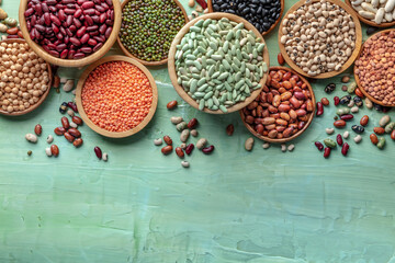 Various legumes, overhead flat lay shot on a blue background. Many different pulses, an assortment, with copy space