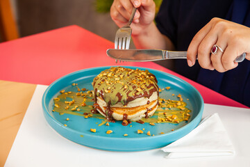 Girl friends eating dubai chocolate kunafa pancakes served at a fancy restaurant cafe.