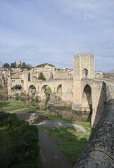 Besalu, Spain - Feb 24, 2025: People walking on Besalu bridge. Streets, buildings. Lifestyle in the urban area. Sunny winter day. Selective focus