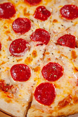 Napolean style wood fired flat bread pepperoni pizza on a white and yellow background.
