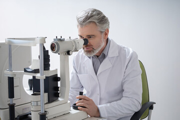 Male ophthalmologist working in his office and looking involved