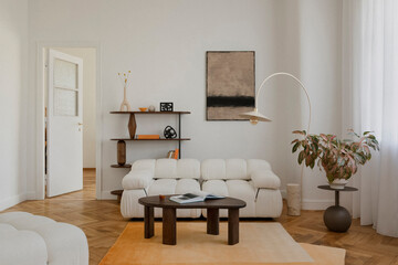Minimalist living room with soft neutral tones, a plush sofa, and wooden accents. A blend of...