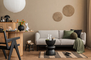 A modern and cozy living room with neutral tones, featuring a gray sofa, natural woven decor, and...