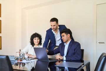 Lawyers working together on laptop in office meeting