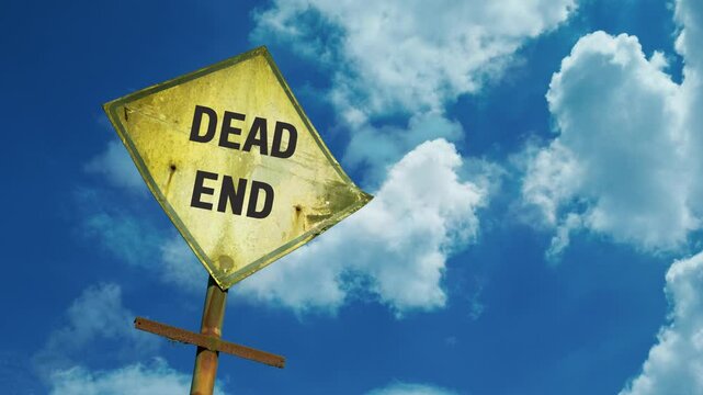A yellow "Dead End" road sign under a cloudy blue sky, symbolizing obstacles, limitations, and the need for redirection or reevaluation