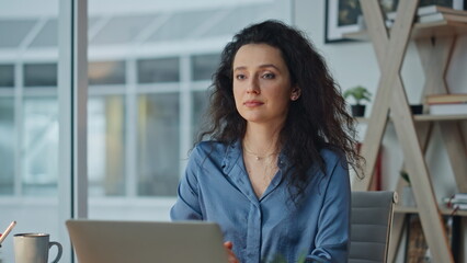 Fototapeta premium Portrait smiling it manager at modern workplace. Successful businesswoman posing