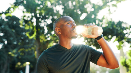 Outdoor, black man and fitness with drinking water for wellness, hydration and nutrition with...