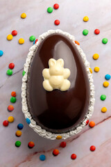 Dark and white chocolate Easter eggs and bunnies with fruit-colored candies and chocolate bars on a counter