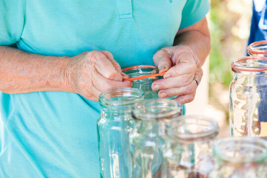 Senior woman putting sealing rings on canning jars