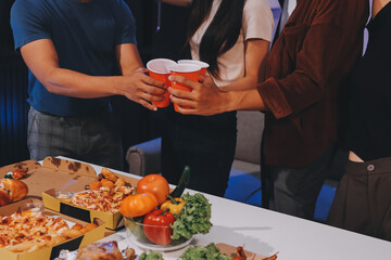 Happy young friends group having lunch at home. Asia family party eating pizza food and laughing enjoying meal while sitting at dining table together at house. Celebration holiday and togetherness.