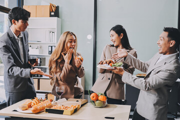 Asian office colleagues and friends enjoy a daytime BBQ with pizza and beer, celebrating Halloween and cheering for their favorite soccer team, creating a lively atmosphere filled with joy.
