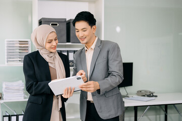Businesswoman leading team meeting and using tablet and laptop computer with financial