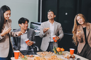 Asian office colleagues and friends enjoy a daytime BBQ with pizza and beer, celebrating Halloween and cheering for their favorite soccer team, creating a lively atmosphere filled with joy.