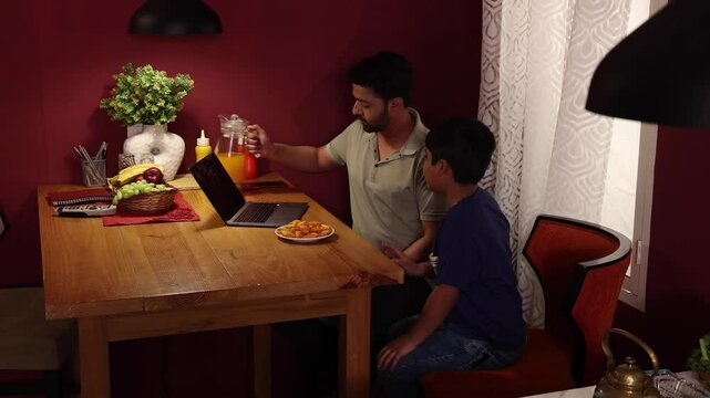 A father serving juice to his child