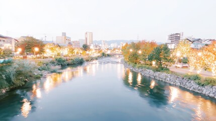 Obraz premium A peaceful river view showcasing twinkling city lights at dusk, surrounded by lush trees and calm waters, creating a serene and enchanting atmosphere.