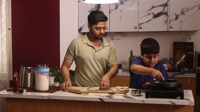 Father and son making chapatis in pan