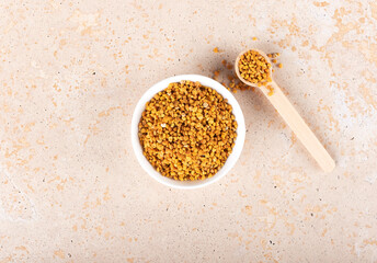 Bee pollen granules on beige background. Natural superfood. Top view