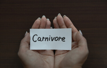 Two hands cupped together holding a white card with 
