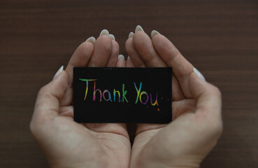 Cupped hands holding a black card with 