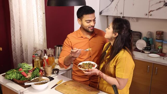 Husband and wife are feeding each other Noodle with love in the kitchen