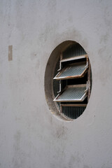 Old round window on a concrete wall