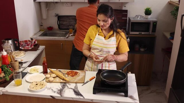 Husband and wife are both cooking together in the kitchen