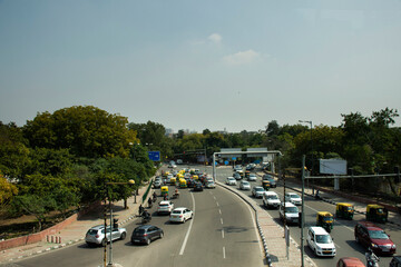 Indian people and foreigners drive car and ride motorcycle and bike bicycle and walk on street with traffic road at New Delhi city in New Delhi, India