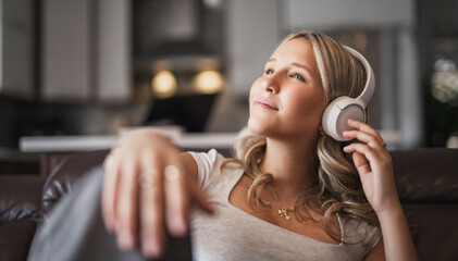 Fototapeta premium teen listening to music with wireless headphones sitting on a couch