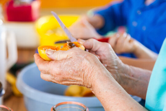older woman preserving fresh fruit in canning jar