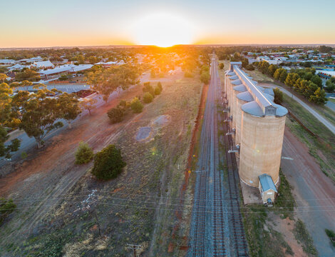 Aerial photo of grain silos beside train track in the Riverina at sunset