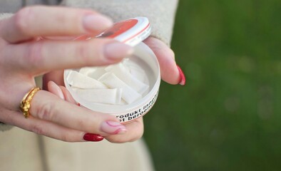 A girl opens a box of snus