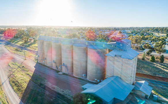 Morning sunlight shining over wheat silo infrastructure beside a train line in the riverina