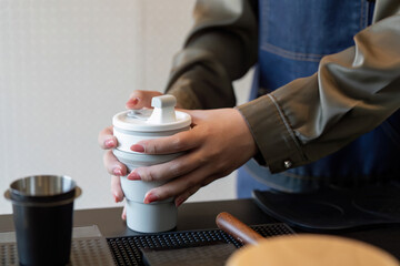 Eco-friendly Practices and Customization. A barista prepares a reusable cup for a customer while ensuring sustainability in service.