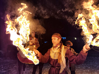 Fire dancers illuminate a winter night with ethnic theatrical performance inspired by Viking culture