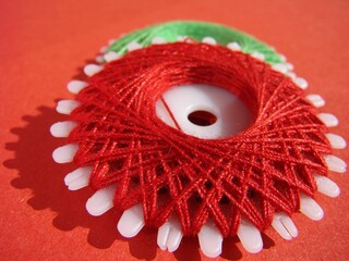 Kolorowe nici nawinięte na specjalną szpulkę kołową