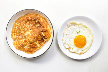 omelet and fried egg isolated on white background